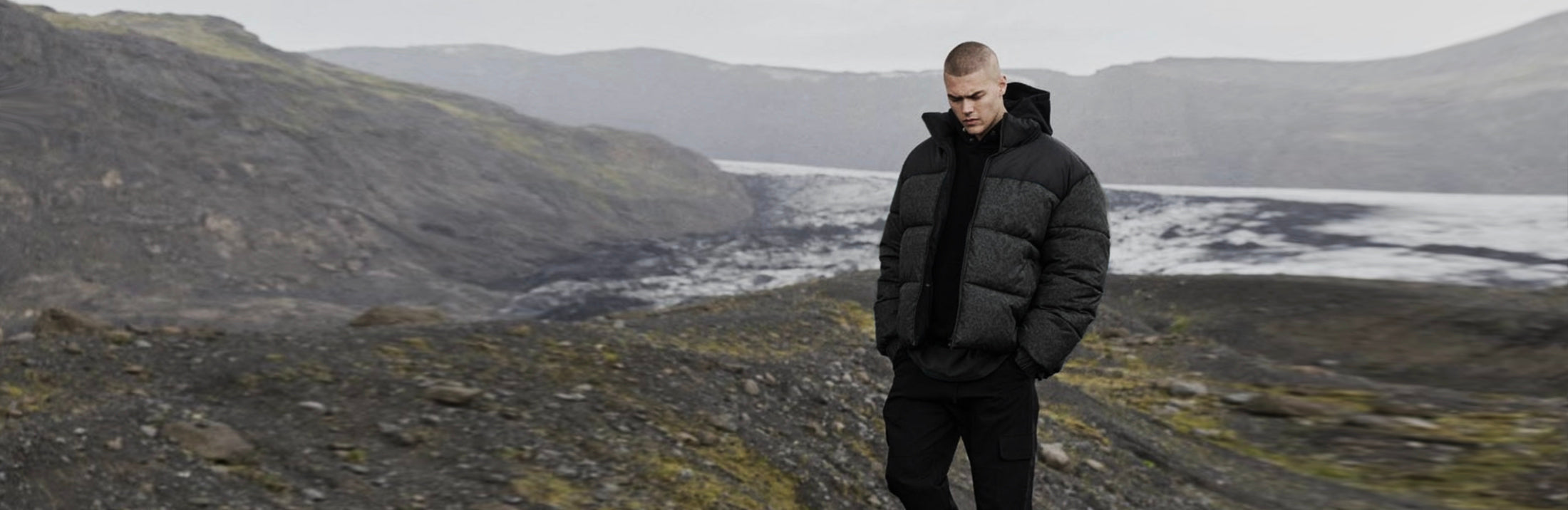 Mies ulkoilee mustassa takissa ja housuissa